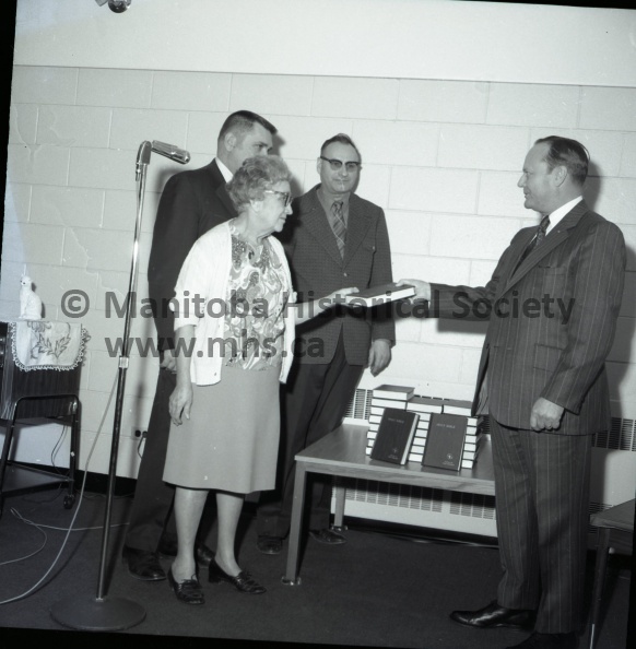 March 30, 1972, Gideon International, Portage Camp, Gideon International presents 30 Bibles to Lions Prairie Manor, Portage Camp of Gideon International recently presented 30 volumes of the Holy Bible for use by residents of Lions Prairie Manor. N. M Tilley, right Portage president made the presentation to Jo Maguire, Also taking part in the presentation ceremony were Manor administrator Aime Omichinski, at extreme left and local camp secretary N. D Tyler, centre, who offered the dedicatory prayer, The presentation was witnessed by a good portion of residents at the Manor. 5693b.jpg