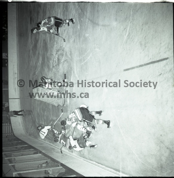 (Tashiro) Nov.26/67 Sports
Junior Hockey Games
Dauphin Defeats Portage Terrier By 4-1
TIM GREENLAY waits in vain in front of the dauphin net as both Murray Cobbe, 16, and Allan Rollins, 17, fight for the puck behind the cage. Rollins is groping for the disc but Dauphin's No. 4, Bert Robinson holds him back with his stick. Dauphin captain Cliff Mullaney, No.11, has control of the puck while No.3, Alex Stherland, guards Greenlay in front of the net. In other league action Sunday Selkirk remained undefeated with an 8-2 victory over winless Fort Garry. 11295e.jpg