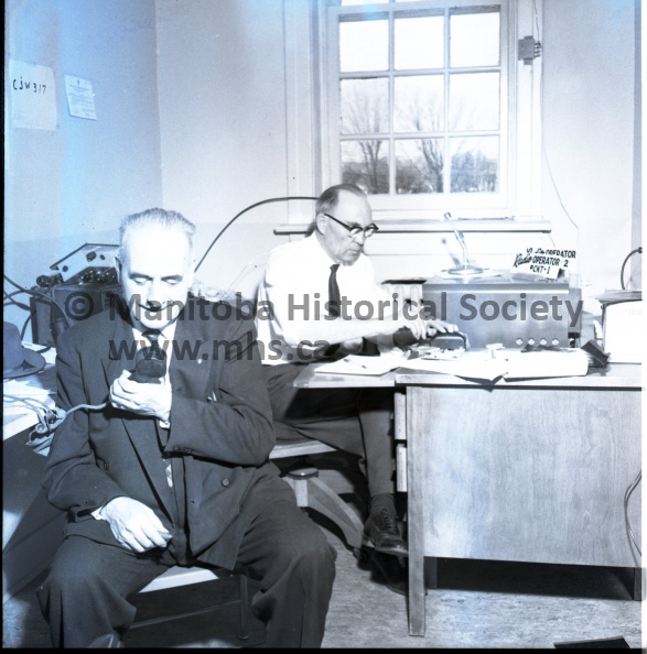 (Tashiro) May 3 - 1960 Civil Defence
Civil Defence Drill Goes Smoothly.
Communications during Tuesday's civil defence exercise went smoothly through headquarters office in POrtage. George Brockie, at left, was in charge of communications and Fred Searles, a communications officer with the provincial CD organization headed the directing staff. 10767a.jpg