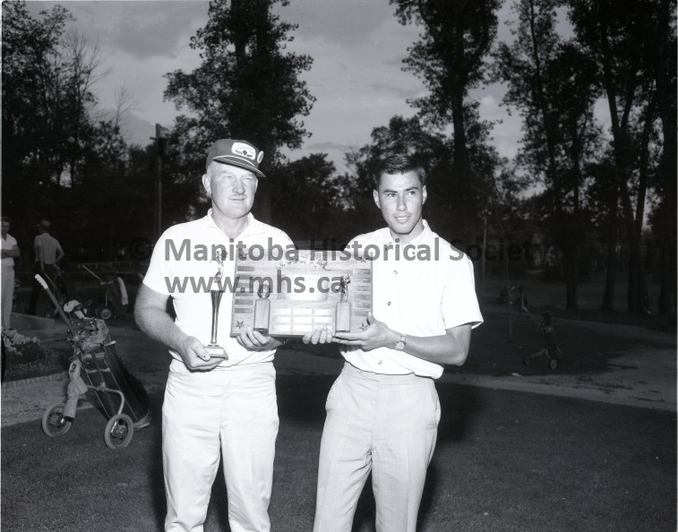 (Tashiro) Aug 8/65 Sports
Left Handed Golfers
Dauphin's Bud Miller - Champion
W. E. Bud Miller of Dauphin, left, accepts the Mayfair Trophy from Portage club professional Herb Scarrett after winning the Canadian left-handed open golfing championships Sunday at the Island Park course. 2050b.jpg