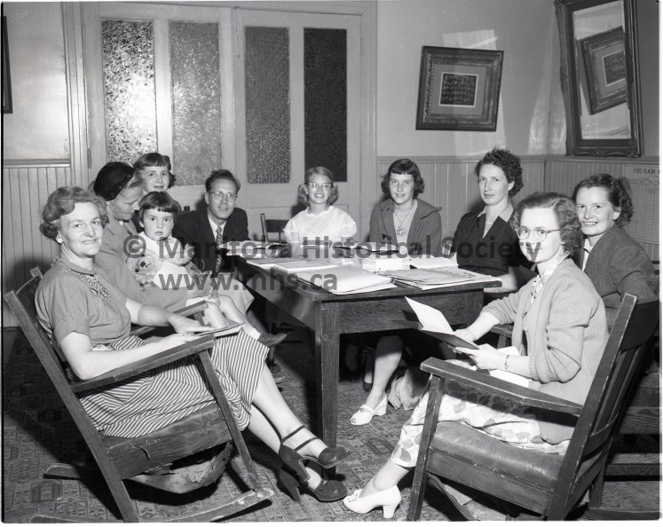 July 24/53 News
United Church Deaconess
Shown above are the teachers and executive responsible for the directing of the Vacation Bible School held in the United Church basement starting July 27 and continuing until Aug. 7. From left to right they are: Mrs. Hatlelid, Mrs. Thelma Carter Laurel Green (on knee), Mrs. Lois Stewart, Rev. McLean, Marlene Chisney, Marlene Ogilvie, Mrs. Bella James, Mrs. Shirley Green, Miss R. Lazenby.
Miss Ruth Lazenby shown above, recently accepted the duties as deaconess of the United Church. She filled the position vacated earlier by Miss Betty Carkeek who left to be married. 10605a.jpg