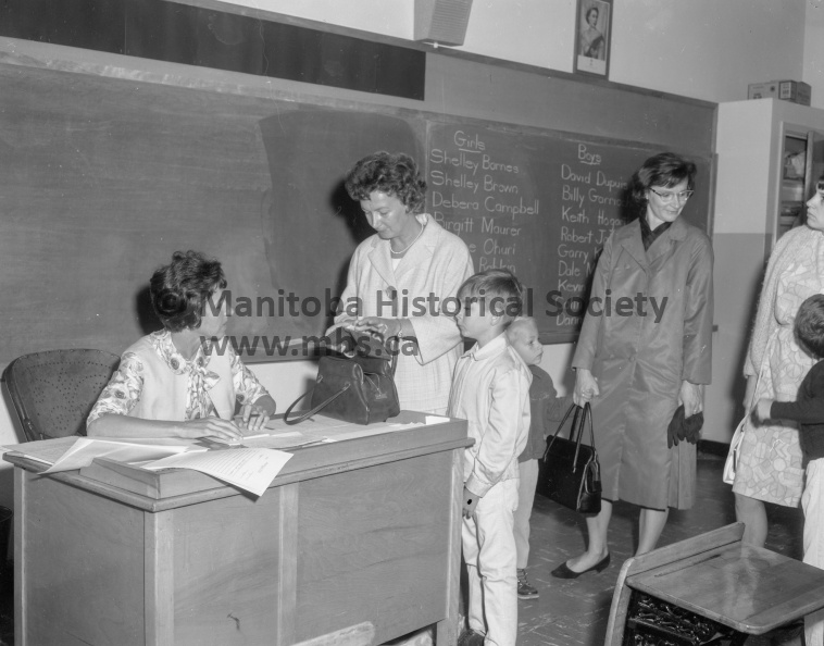 Photographer: Tashiro
September 6, 1966
Education
Schools commence another term - 1,100 enrolment in high schools
First day in school — Keith Hogarth joined the school population in Portage la Prairie this morning, along with scores of other young boys and girls stepping out into a new world. Here he “signs on” in Mrs. Clarice Brown’s grade one class at Victoria school as Mrs. Hogarth looks on. VP-1-00093-001.jpg