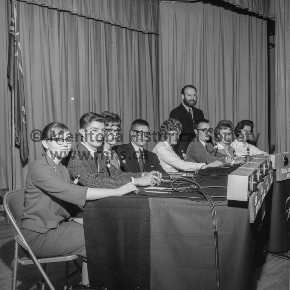 Photographer: Tashiro
October 25, 1963
Educational
Portage Collegiate foursome battle Neepawa group in CBC’s national “Issues and Answers.”
Here are the contestants who participated in the CBC’s Issues and Answers panel quiz competition at the Portage Collegiate Auditorium on Friday afternoon. From left to right they are Pam Madson, Fred Kosmulak, Joy Henry and Bob Jackson of Neepawa Collegiate and Geraldine Norris, Graham Jones, Shirley Hovan and Sue Lynn Hinds of Portage Collegiate. Standing is Jed Adams, host-moderator for the program. VP-1-00602-001.jpg