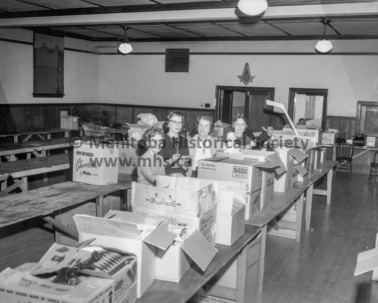 Photographer: Tashiro
December 23, 1965
Dorcas Soc.
Dorcas ladies complete another Christmas
The Dorcas parcels went out today to some 150 families and senior citizens in Portage. The Dorcas work crew on deck early this morning to oversee the chore included the four above. Left to right are Mrs. E. M. MacKey, Mrs. E. L. Burk, Mrs. C. J. Janaway and Mrs. W. H. Wilson. VP-1-00736-001.jpg