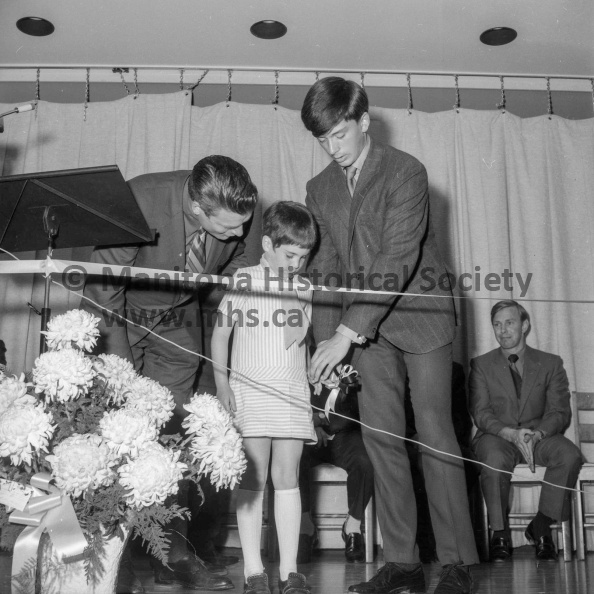 Photographer: Moffat
June 15, 1970
Yellowquill Sch.
Yellowquill School officially opened at a ceremony
A helping hand and a little encouragement — and Miss Dawn Fyke cut the ribbon that officially opened the new Yellowquill school Monday afternoon. At left is Trustee Jack Kissock and Calvin Brown hands the scissors to Dawn. VP-1-00347-001.jpg