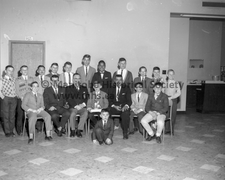 Photographer: Tashiro
March 30, 1965
Sports
Southside A.C. hockey wind-up
Southside Peewee city champions were presented the ANAF trophy Tuesday at the Southside “Father and Son” banquet in the ANAF hall. Kneeling in front is mascot Angus Moar. Seated, left to right, in front row are Ian McMillan, coach Mel Hale, Alderman Webster Burton, who made the presentation of the trophy; co-captain Garry Batters, coach John Moar, Gordon Hansen, and David Taylor. Standing, left to right, in rear row are Garry Perkins, Marvin Streick, Stanley Yee, Frank Reashore, Jim Crosland, Wayne Orpin, John Cook, and Ken Sloik. Missing from picture is co-captain Monty Kerr. VP-1-00408-001.jpg