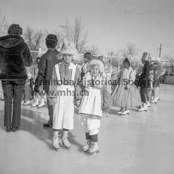 Photographer: Tashiro
February 21, 1971
West End Comm. C.
West End Community Club annual carnival
Mid-20 temperatures Sunday were made to order for organizers of the West End Community Club's annual family carnival. Little Bobbi-Jo Holland and her older sister Leslie Anne, both winners in their class in costume judging, were able to display their mother's handywork in comfort. Spectators, young and old, under the warm sun, were able to remain outside without heavy mitts, overshoes and ear muffs. VP-1-00437-001.jpg