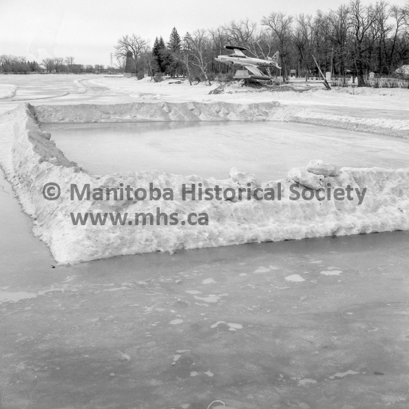 Photographer: Tashiro
March 5, 1973
Fun Festival
Weatherman is not co-operating with festival committee
Cold spell will help
This broomball pit was half-covered with water by noon Monday. While the dominant snowbank placed there to keep straying balls within the playing confine escaped unscathed by warm temperatures Sunday, the actual playing surface was under water. Unless weather tightens, it won't be too comfortable for participants in the Winter Fun Festival broomball tournament this weekend. VP-1-00473-003.jpg